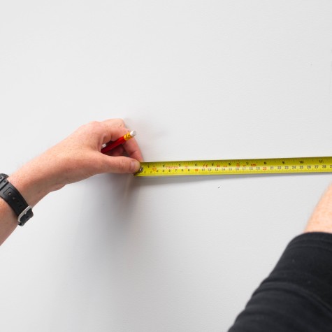 using a tape measure to plan out wall space
